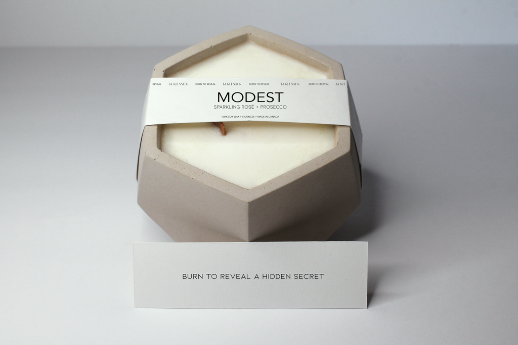 Modest concrete candle that is scented with sparkling rose and prosecco