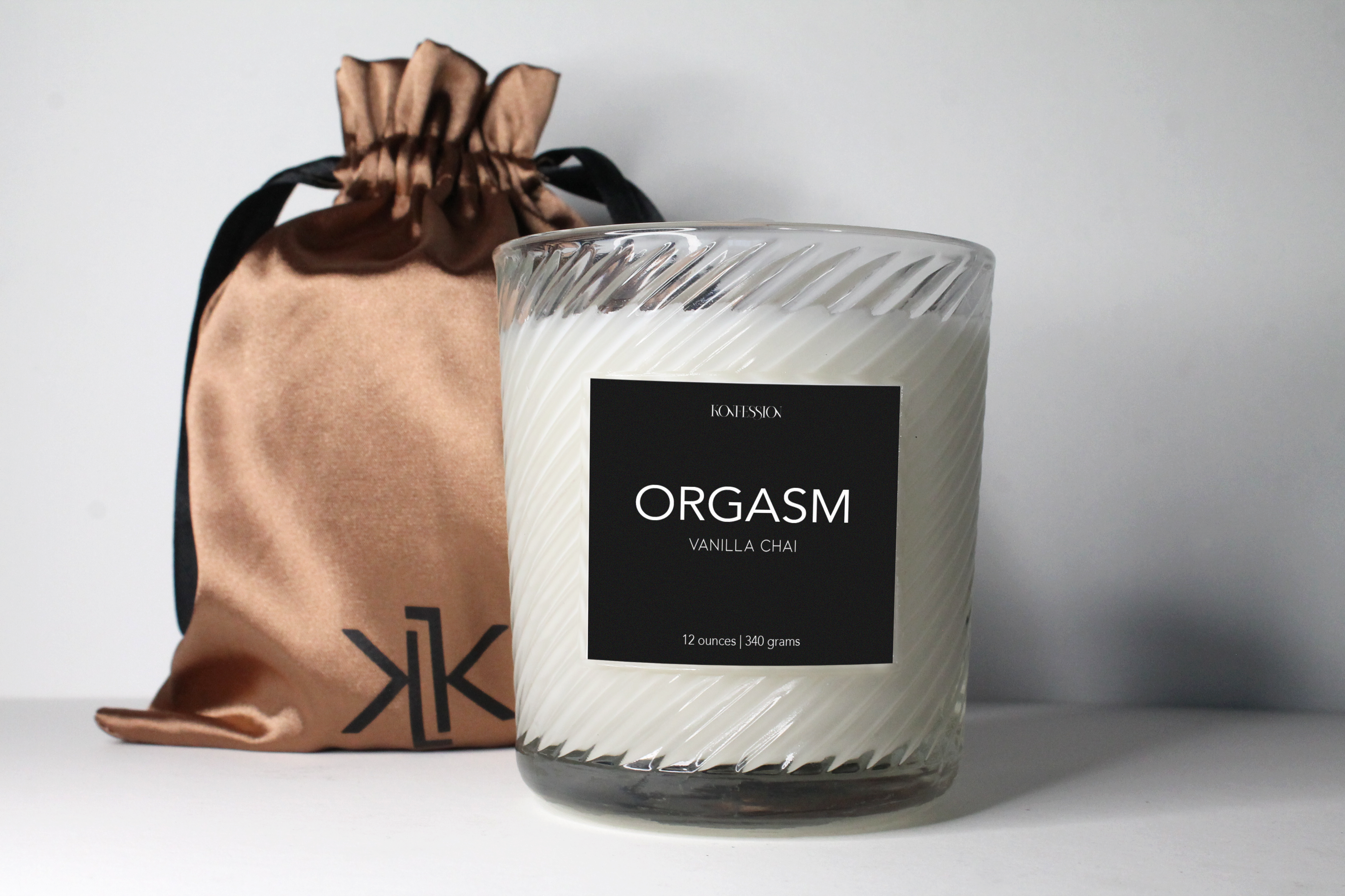 Orgasm candle is in scent vanilla chai. Places in a 12 ounce clear ribbed candle vessel. Black label and 100% soy wax.